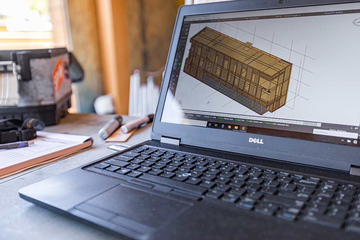 Laptop computer screen shows digital model of commercial building