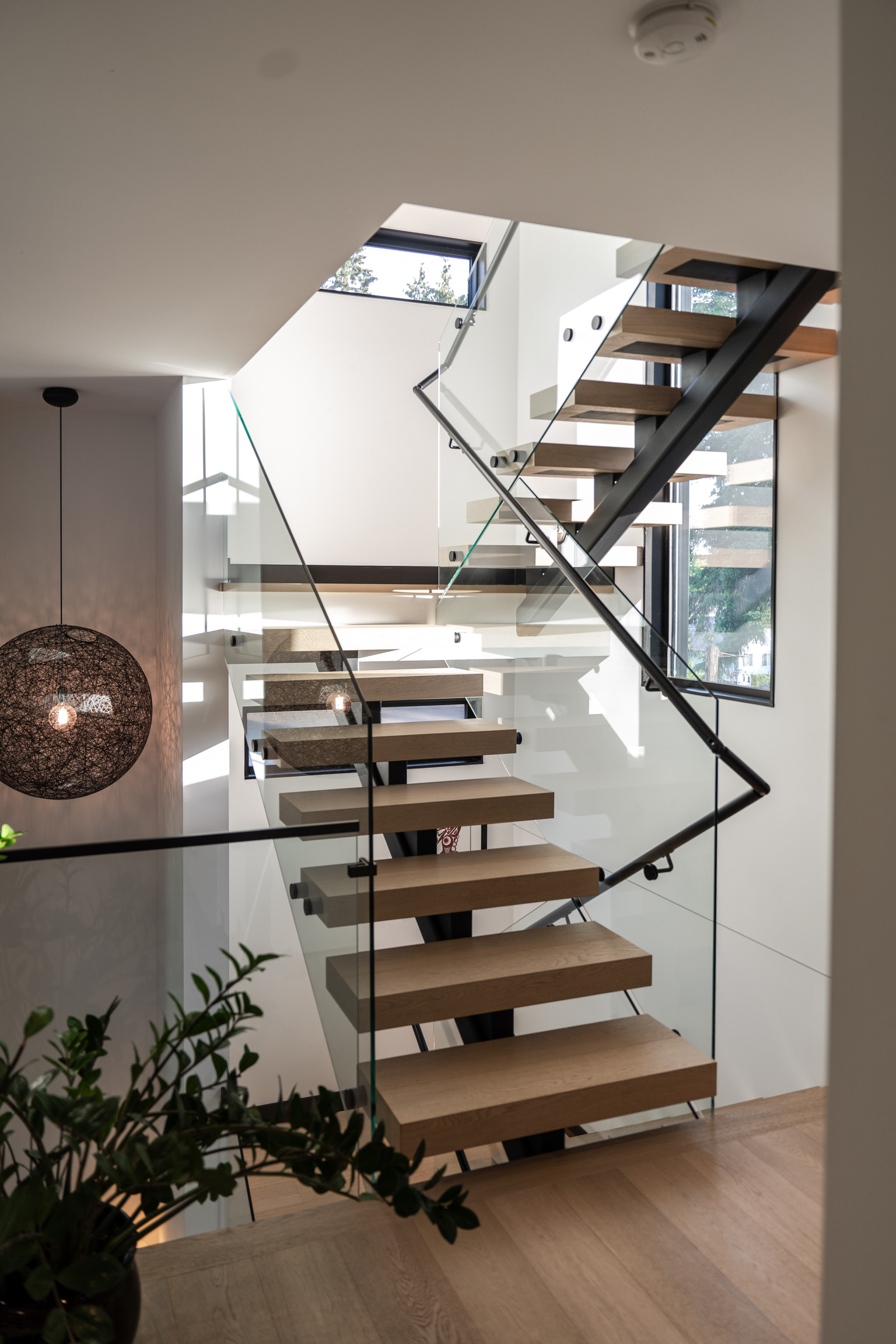 Airy wooden stairs with glass railing