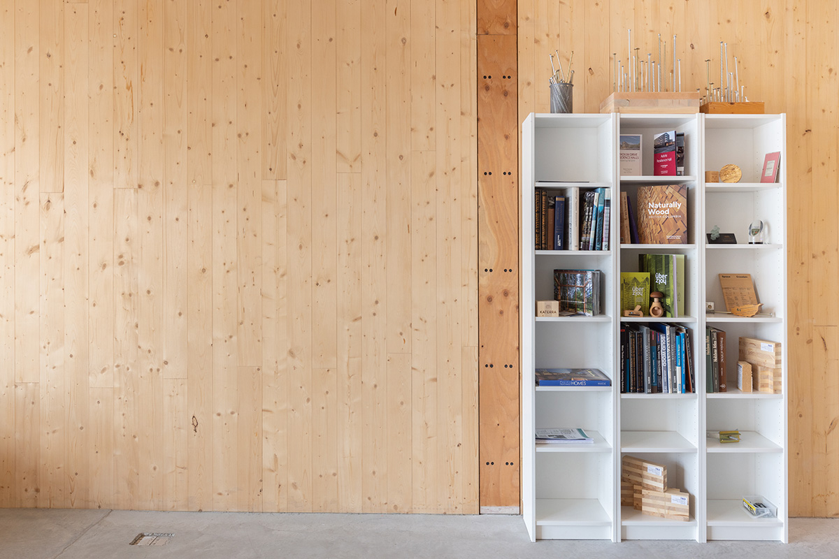 A bookshelf rests against a wood panelled wall